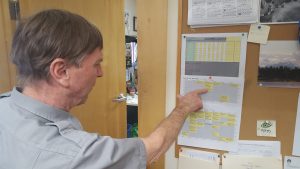 Roger Robinson looks at the schedule of arriving climbing parties.  Photo by Phillip Manning, KTNA.