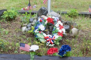 A wreath and symbols of remembrance were laid before the flag pole at the Talkeetna Cemetery on Monday. Photo by Phillip Manning - KTNA