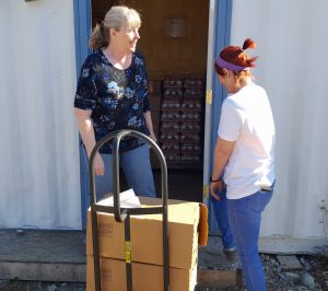 LouAnne Carroll-Tysdal [L] and volunteer Holly Beard [R] load a hand-truck to bring food into the Upper Susitna Food Pantry. Photo by Phillip Manning - KTNA
